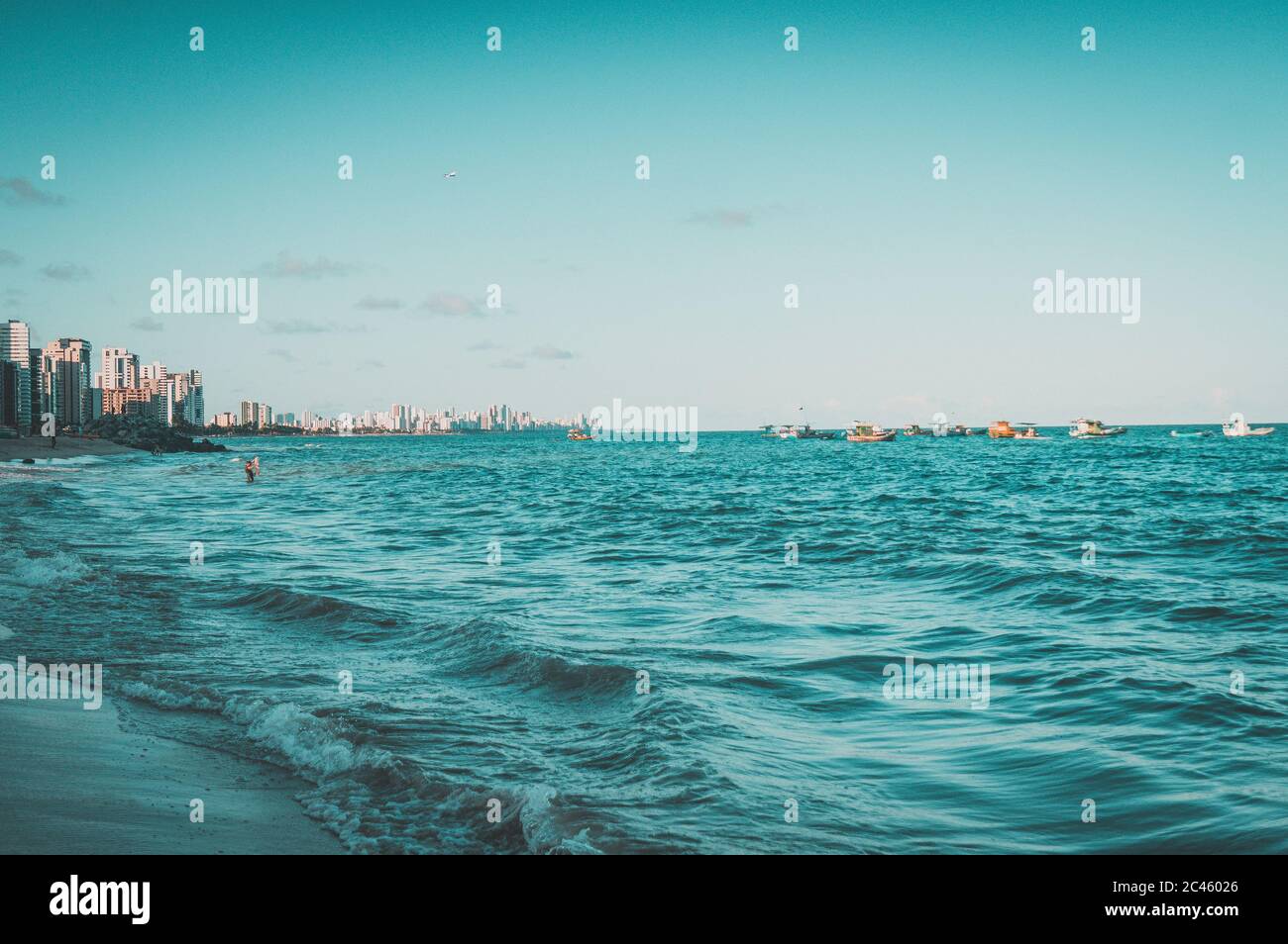 Beautiful scenery of splashing sea waves with tall buildings in the ...
