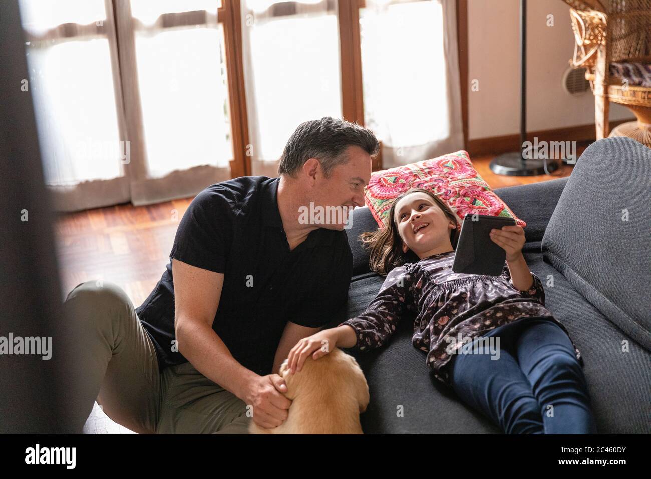 Father and daughter on living room sofa during Coronavirus lockdown. Stock Photo