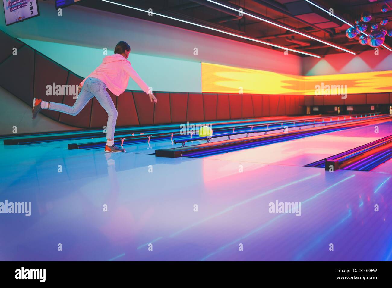 Young girl, tween age, bowling on indoor bowling lane Stock Photo