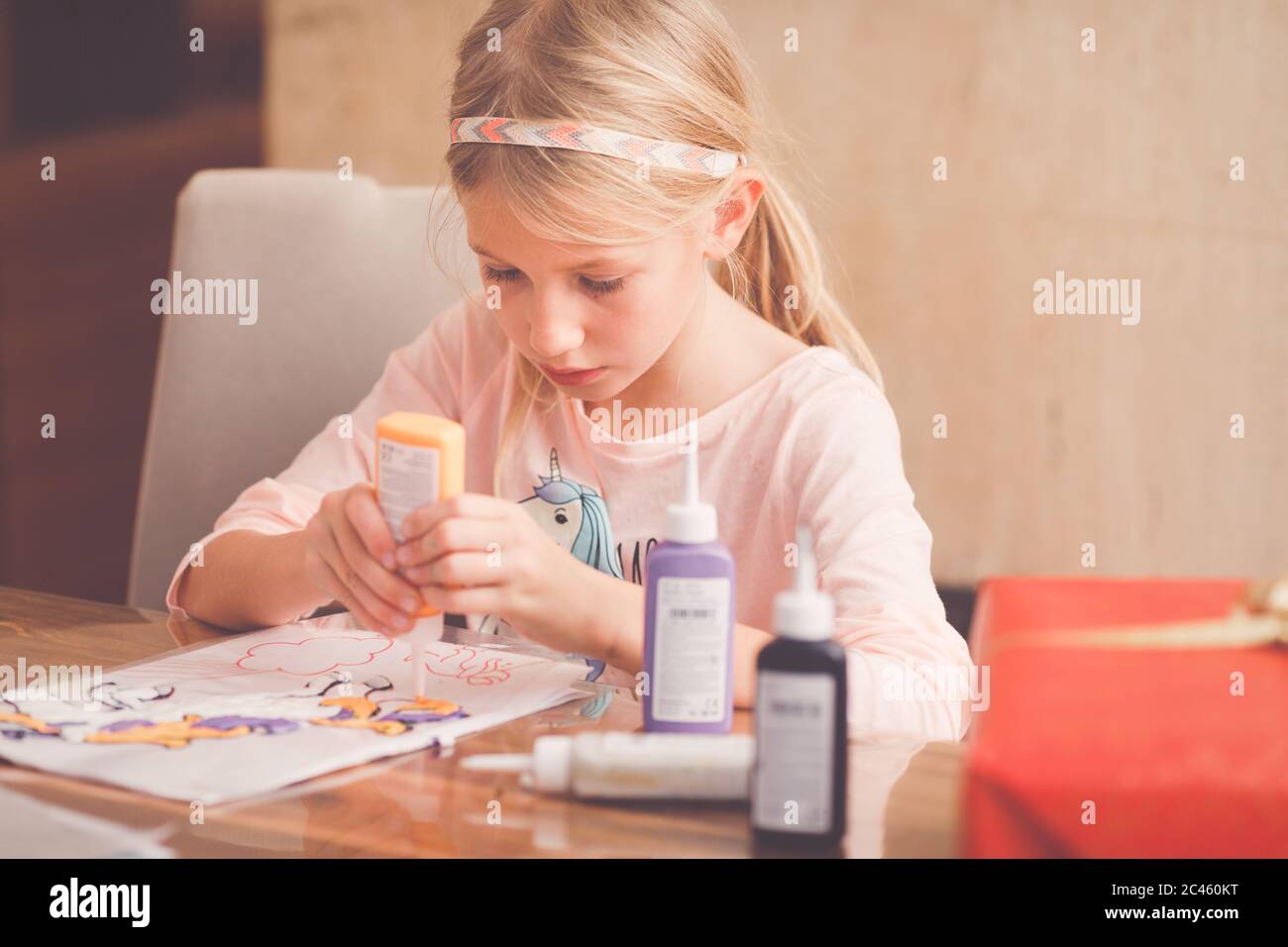 Young girl, primary school age,  doing handicrafts, tinkering with water colours Stock Photo