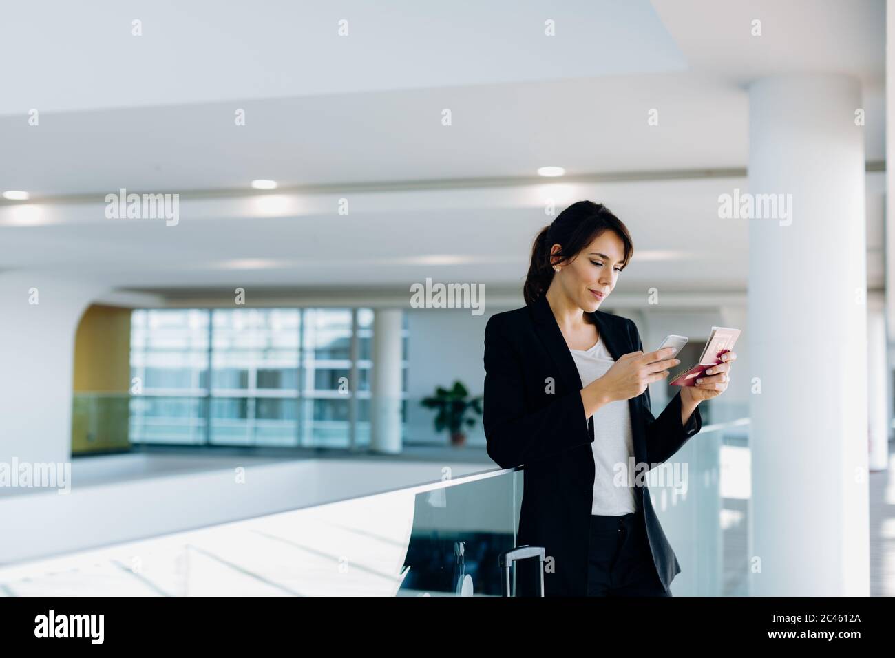 Businesswoman using mobile phone for electronic check-in Stock Photo