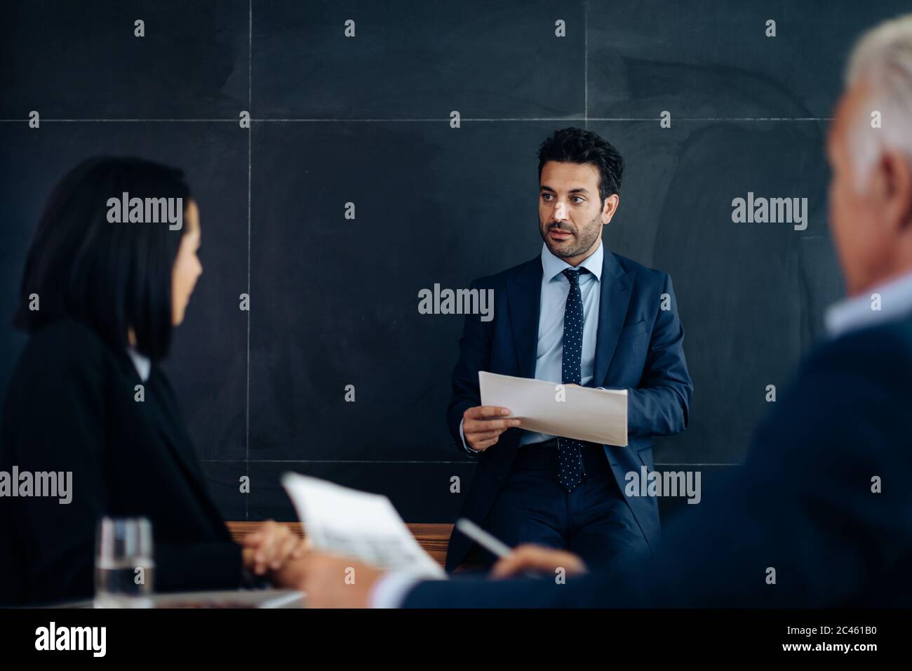 Businessmen and woman meeting in boardroom Stock Photo