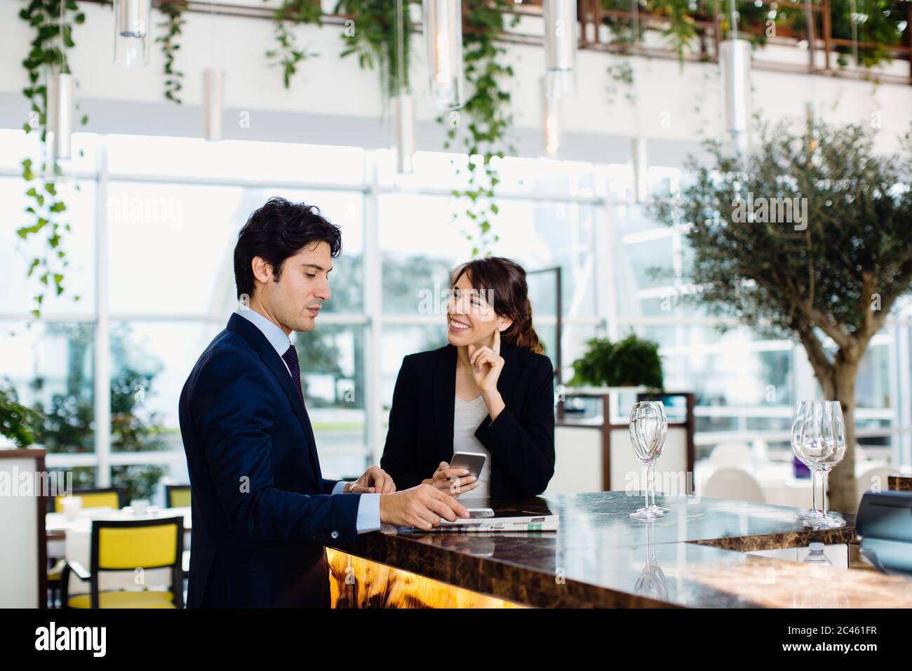 Businessman and businesswoman having drink at bar Stock Photo