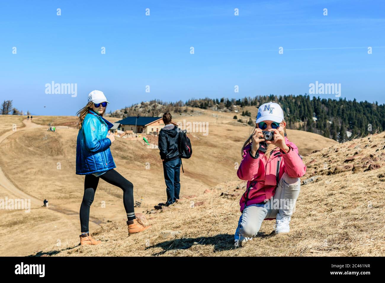 Young girl taking photos in alpine scenery Stock Photo