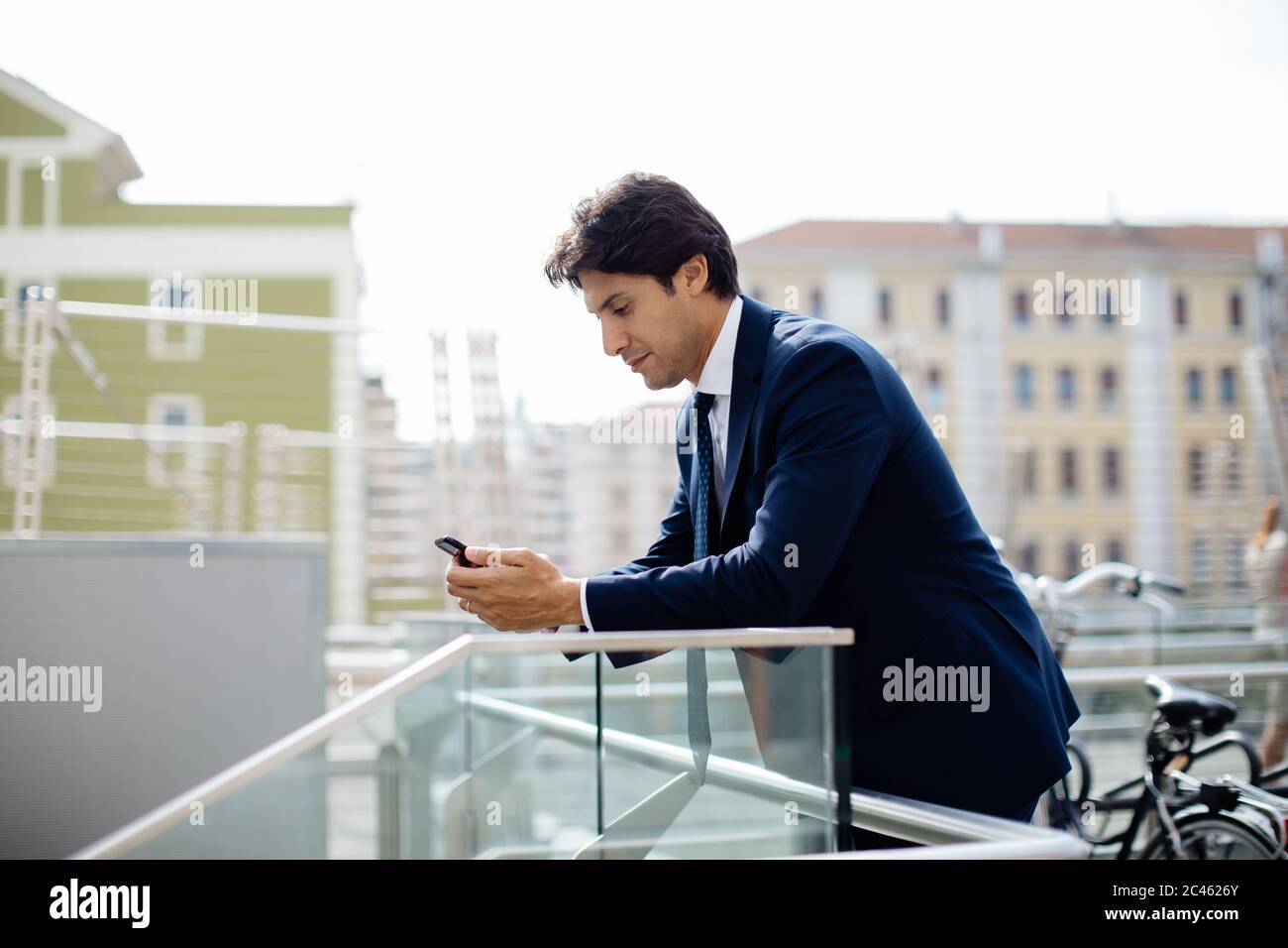 Businessman using smartphone on terrace Stock Photo