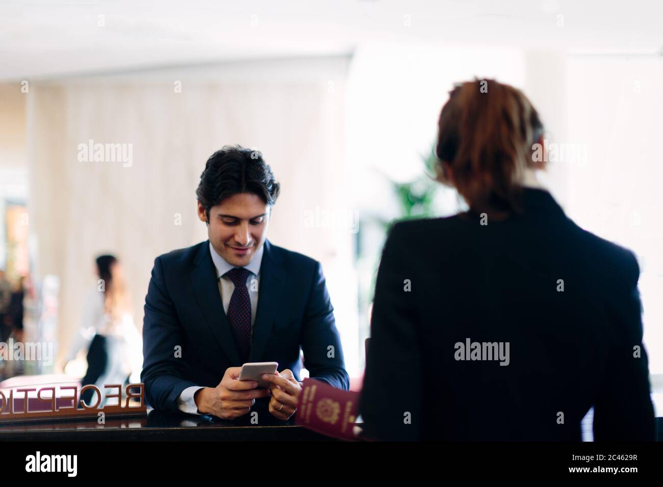 Businessman checking in at hotel reception Stock Photo