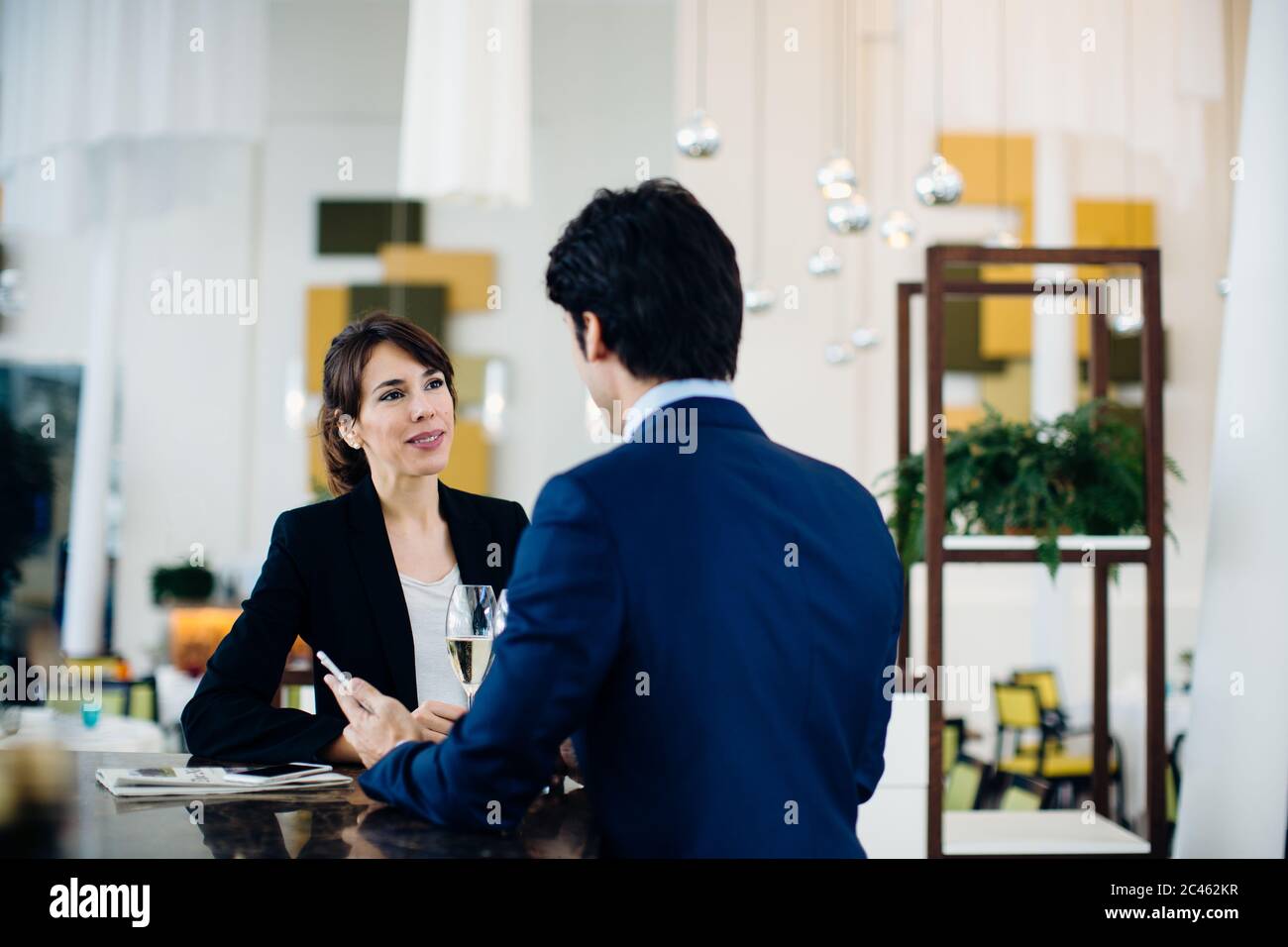 Businessman and businesswoman having drink at bar Stock Photo