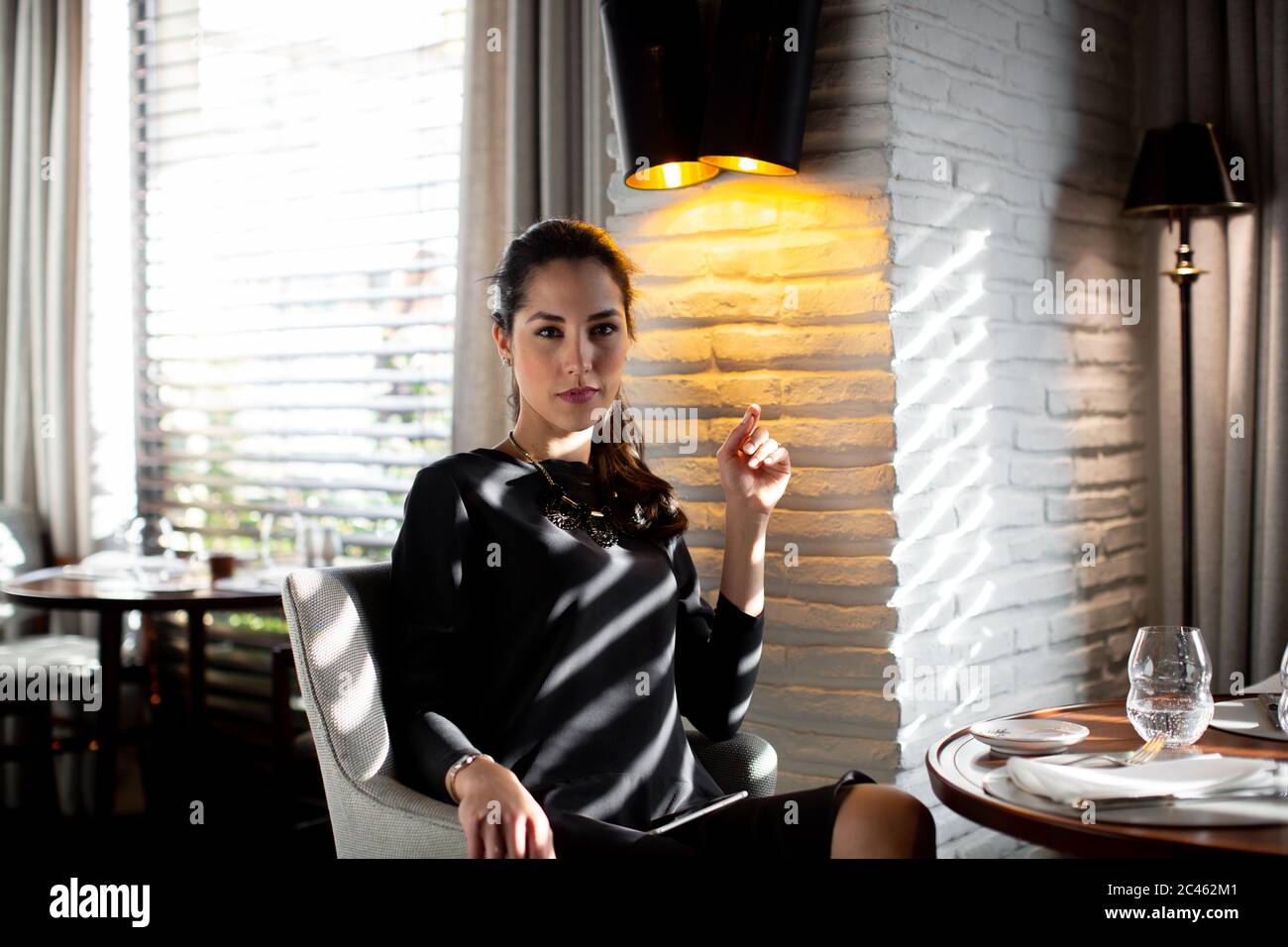 Portrait of sophisticated young woman in boutique hotel restaurant, Italy Stock Photo