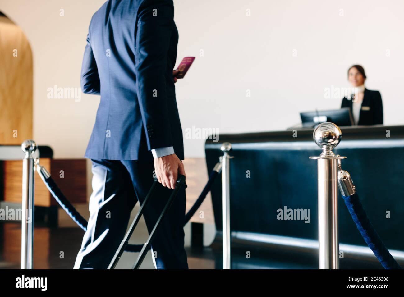Businessman checking in at hotel reception Stock Photo - Alamy