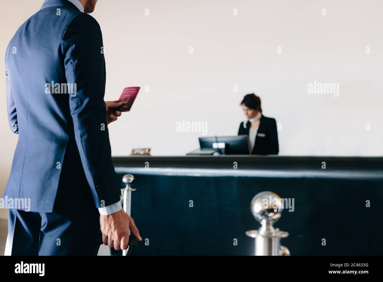 Businessman checking in at hotel reception Stock Photo - Alamy