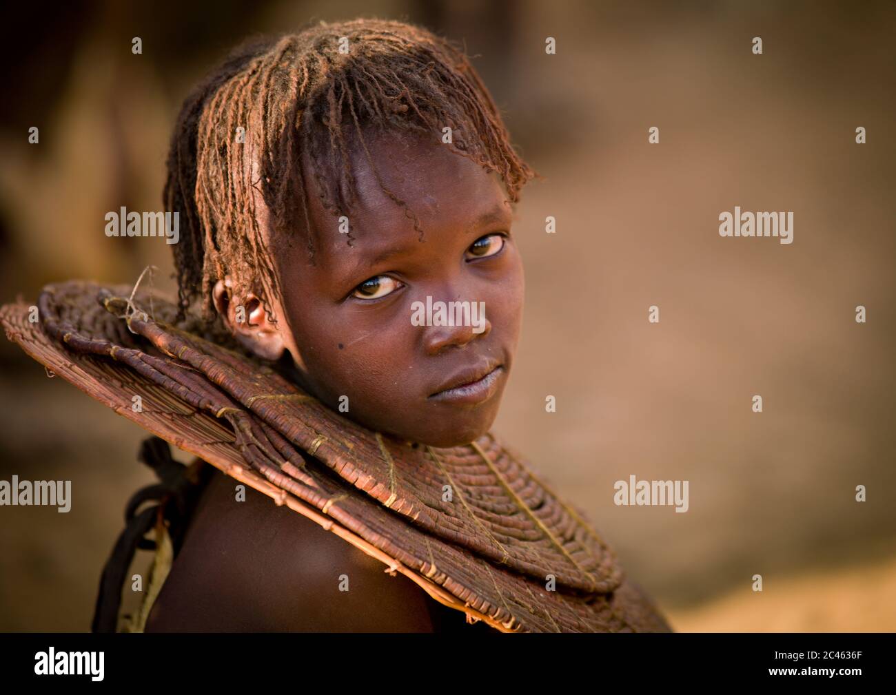 A pokot girl wears large necklaces made from the stems of sedge grass ...