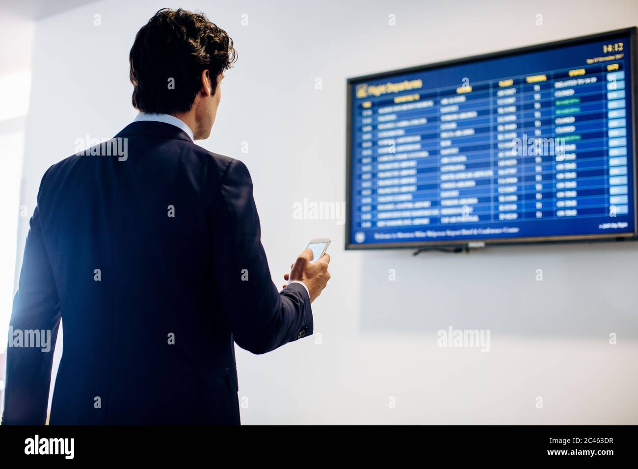 Businessman checking departure board Stock Photo