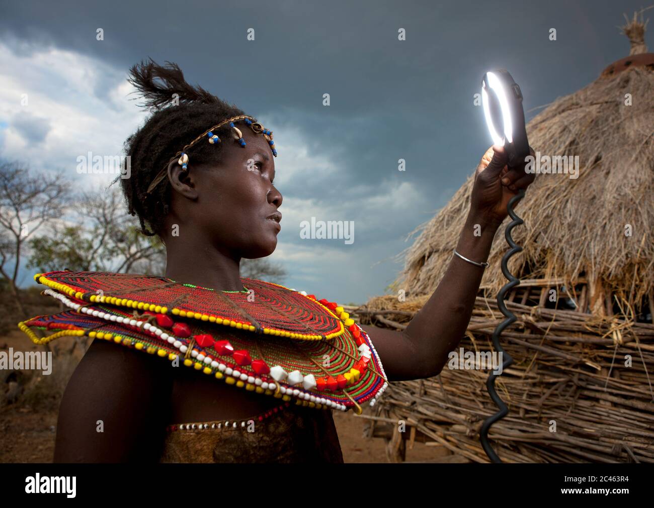 A pokot woman wears large necklaces made from the stems of sedge grass ...