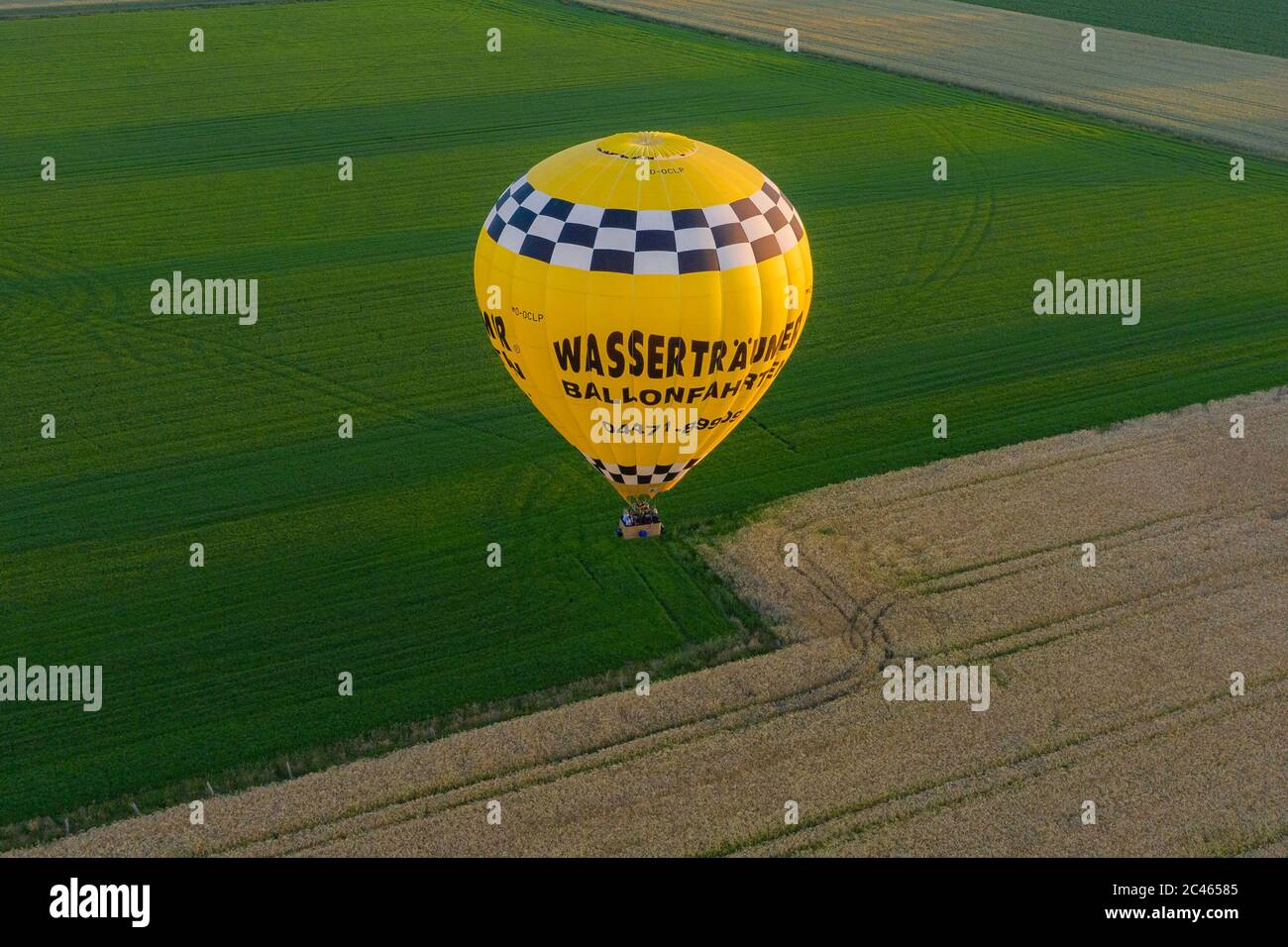 Cloppenburg, Germany. 23rd June, 2020. The band 'Crackerjacks' lands with a hot-air balloon on a pasture after they have held a balloon concert over the town of Cloppenburg (recorded with a drone). Credit: Mohssen Assanimoghaddam/dpa/Alamy Live News Stock Photo