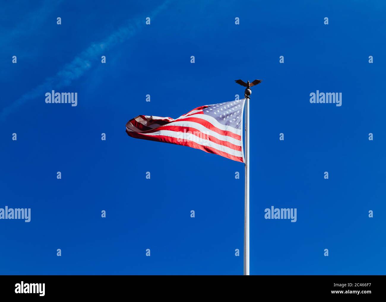 United States Of America Flag on pole in a blue sky background. Symbol ...