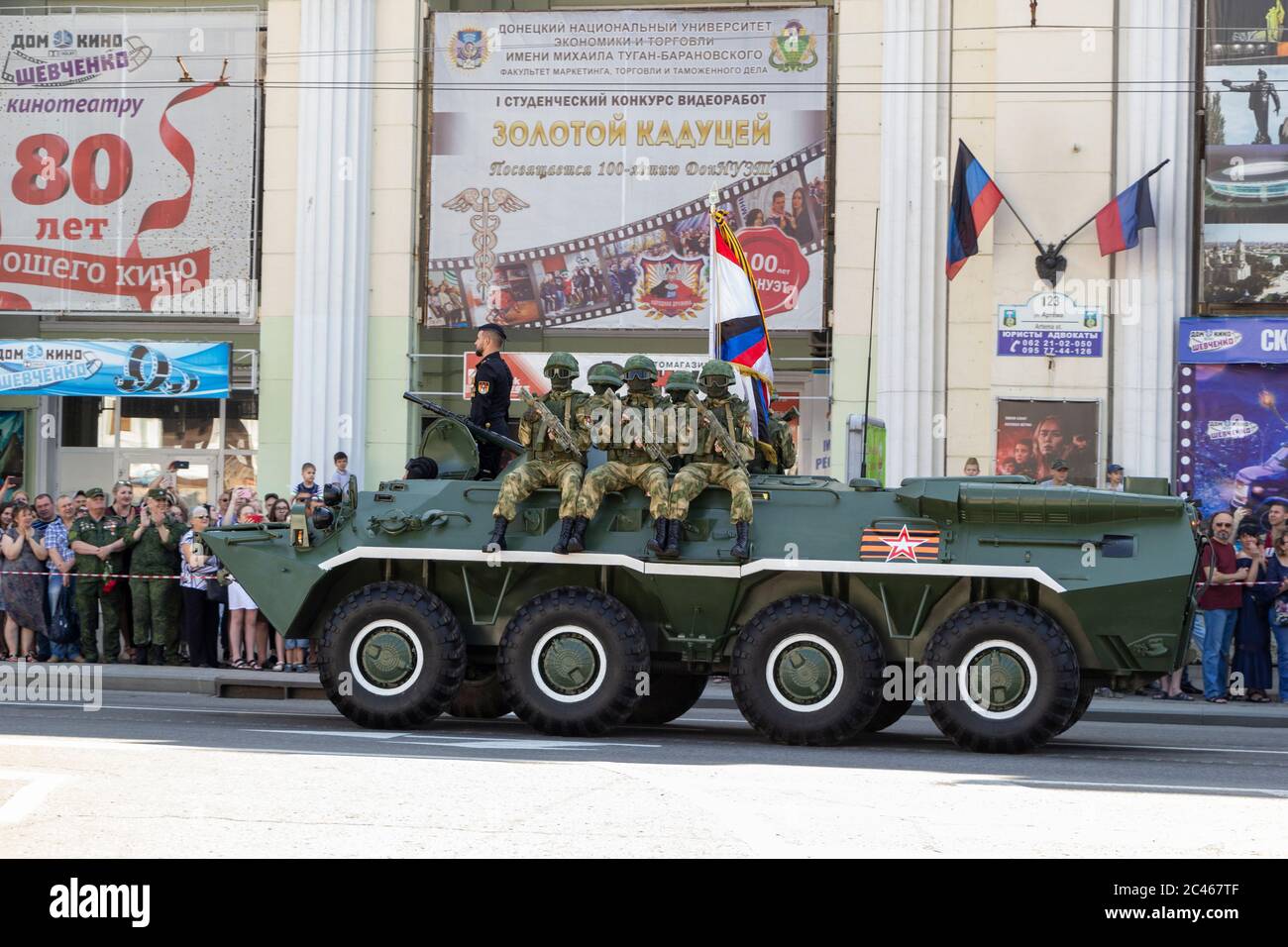 Donetsk, Donetsk People Republic, Ukraine - June 24, 2020: A column of armored personnel carriers with armed soldiers in full outfit on armor move alo Stock Photo