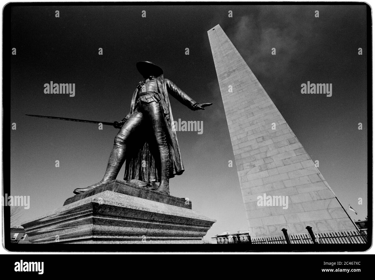 Bunker Hill Monument and Statue of Dr Joseph Warren Boston USA 1988 The Bunker Hill Monument was erected to commemorate the Battle of Bunker Hill, which was among the first major battles between British and Patriot forces in the American Revolutionary War, fought there June 17, 1775. The 221-foot (67 m) granite obelisk was erected between 1825 and 1843 in Charlestown, Massachusetts, with granite from nearby Quincy conveyed to the site via the purpose-built Granite Railway, followed by a trip by barge. There are 294 steps to the top.  An exhibit lodge built near the base of the monument in the Stock Photo