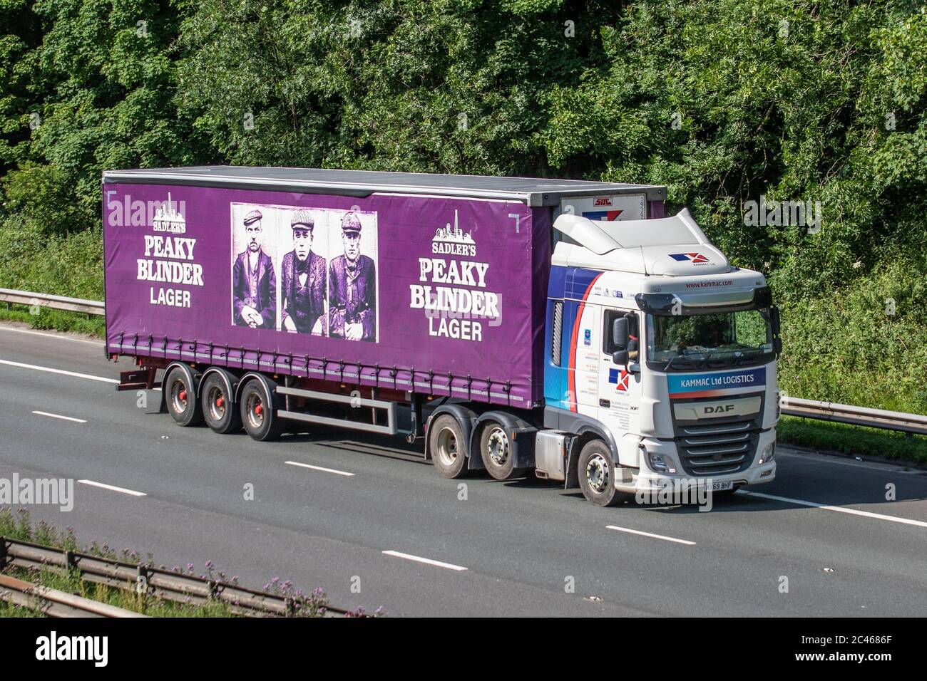 Sadler's Peaky Blinder Lager; Haulage delivery trucks, lorry, transportation, truck, cargo carrier, DAF vehicle, European commercial transport industry HGV, M6 at Manchester, UK Stock Photo