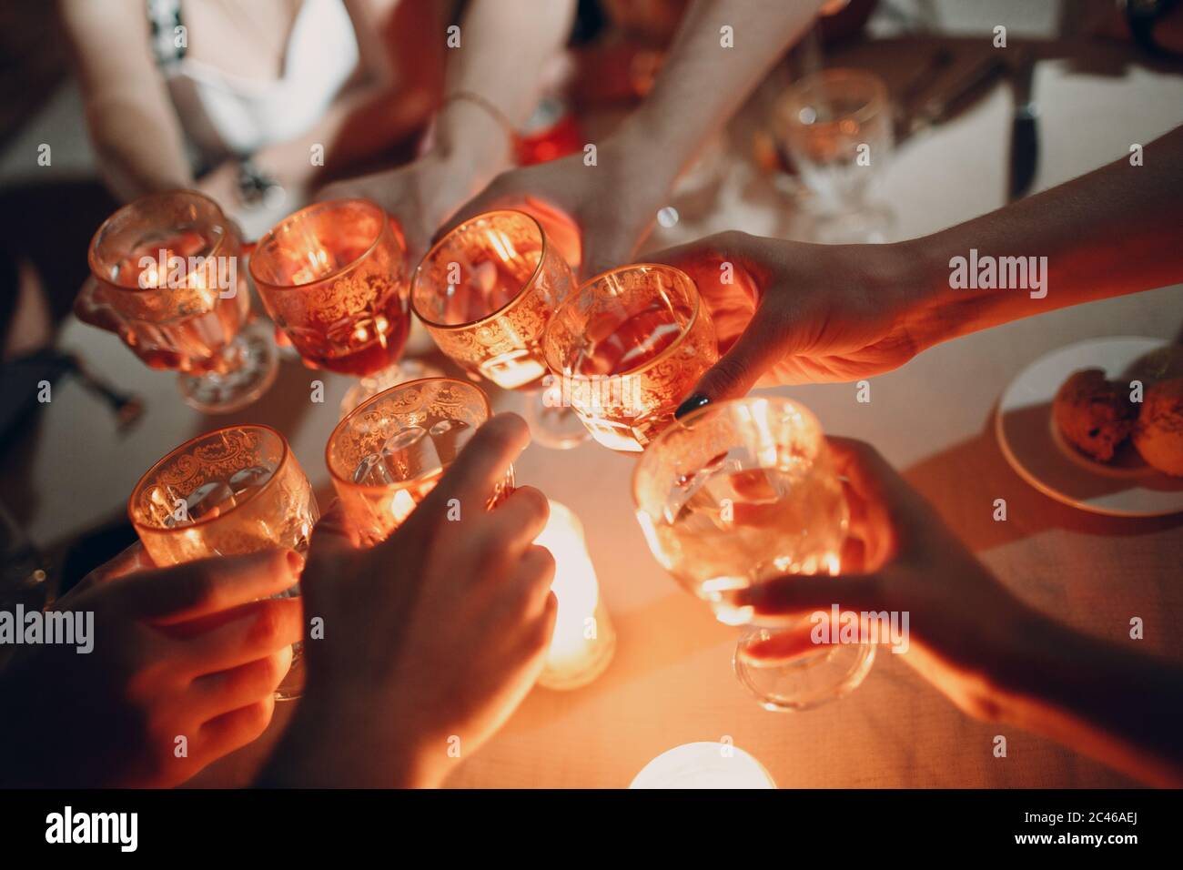Hands holding the glasses with drink making a toast at party. Soft ...