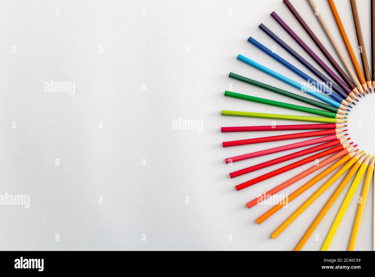 a set of colourful pencils set out in a semi circle going from light to