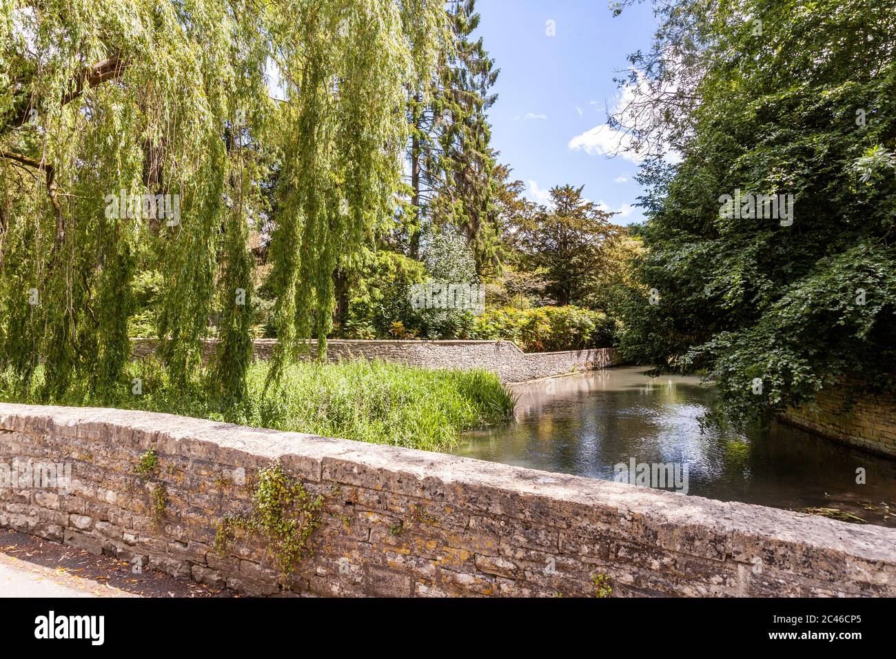 The River Coln flowing past the gardens of Ablington Manor in the Cotswold village of Ablington, Gloucestershire UK Stock Photo