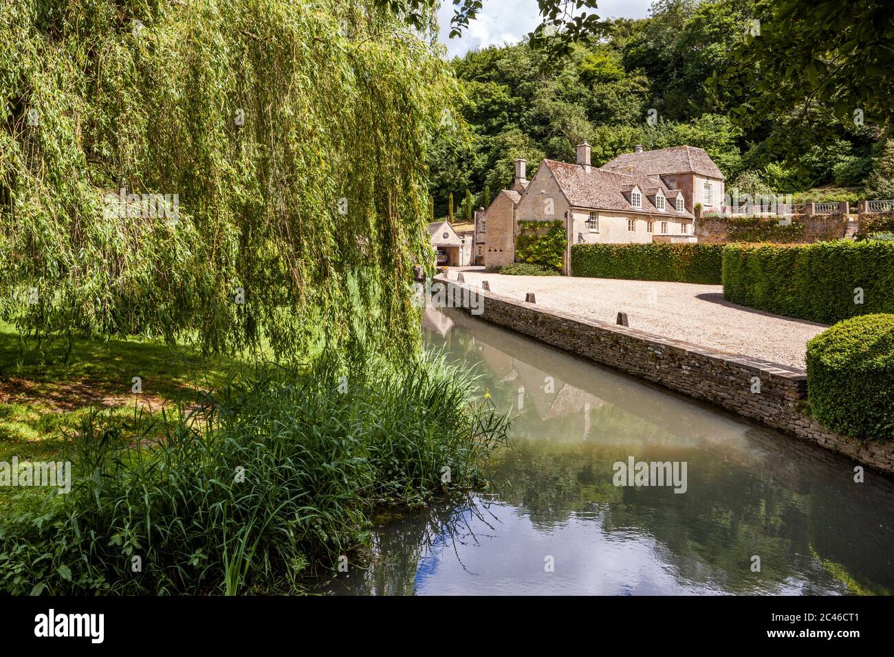 An old mill beside the  River Coln on the edge of the Cotswold village of Coln Rogers in the Coln Valley, Gloucestershire UK Stock Photo