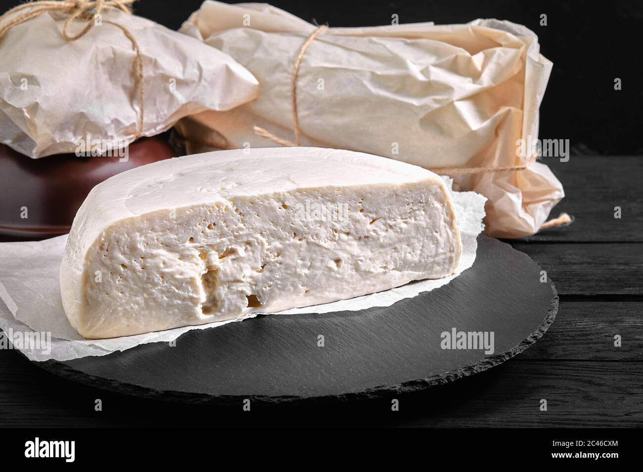 Traditional Caucasian homemade cheese sulguni on stone board, selective focus Stock Photo