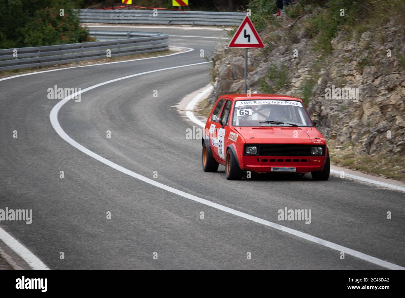 Skradin Croatia, June 2020 Simple red old Yugoslavian 'Yugo' modified for hill climb racing up hill, going through a bend at high speed Stock Photo