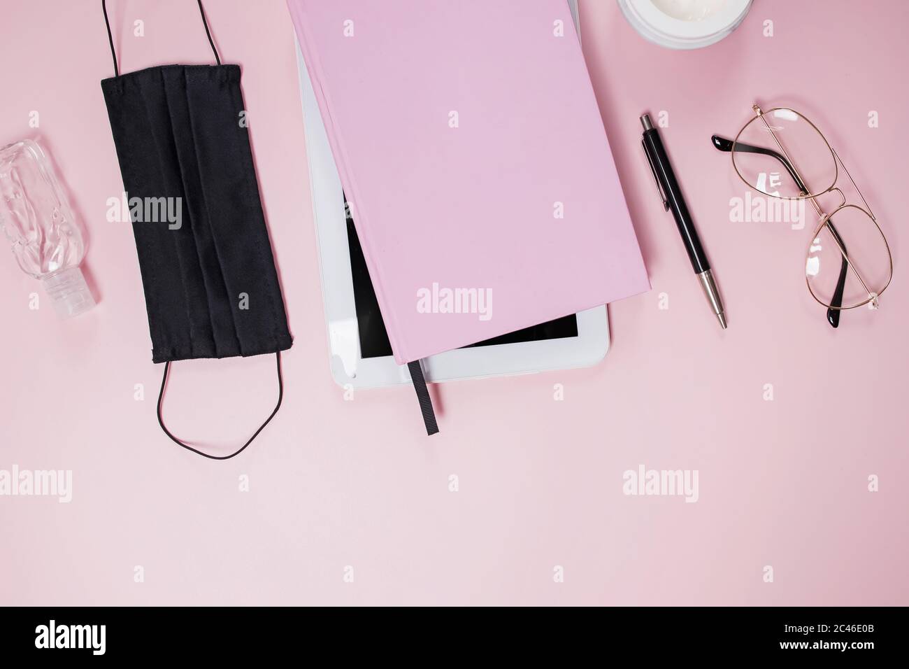 Flat lay composition with medical mask, table, notepad and coffee on pink background. Stock Photo