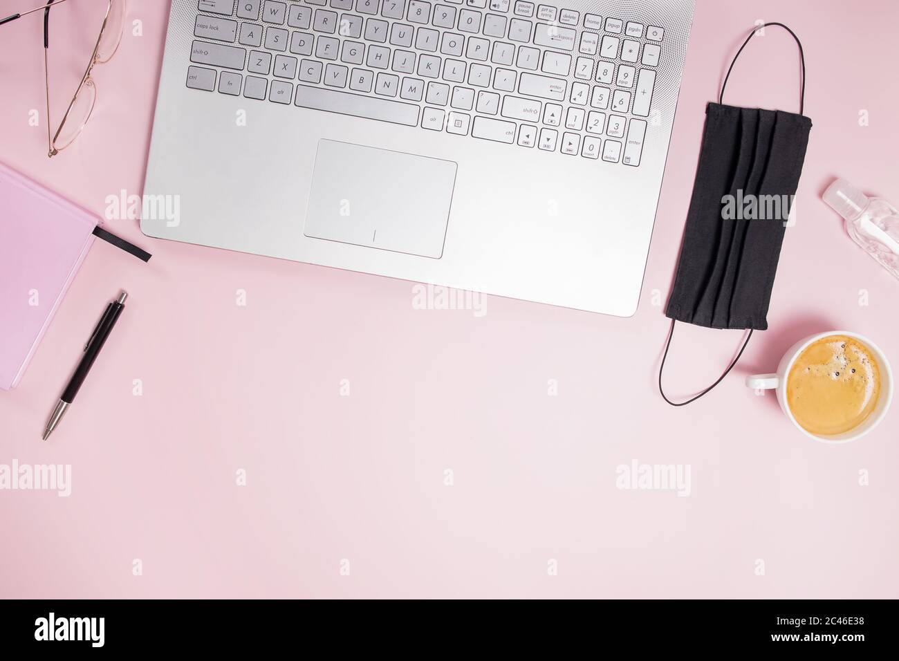 Flat lay composition with medical mask laptop, coffee, notebook on pink background. Stock Photo