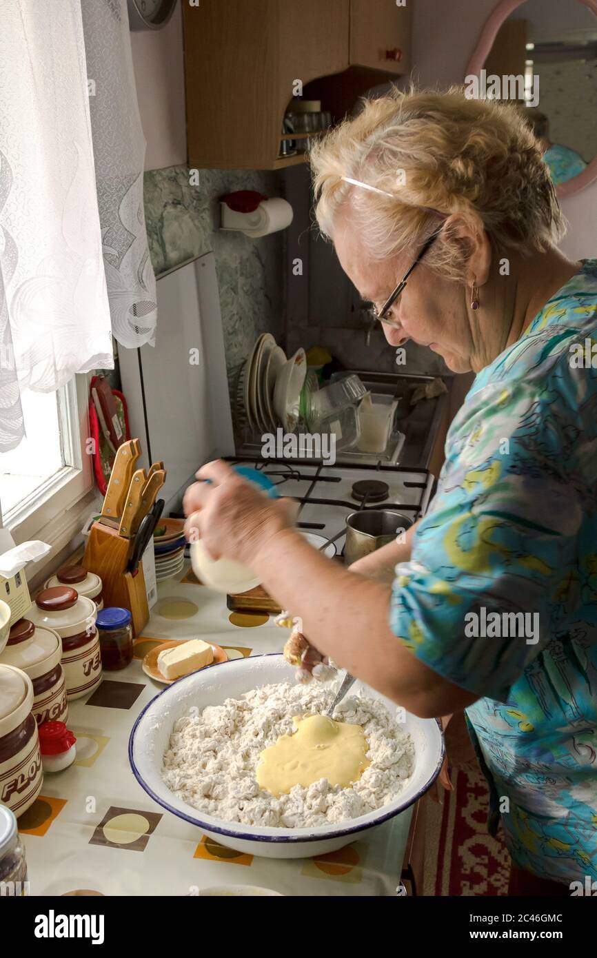 Elderly woman prepares dough for bread, cakes. Stock Photo