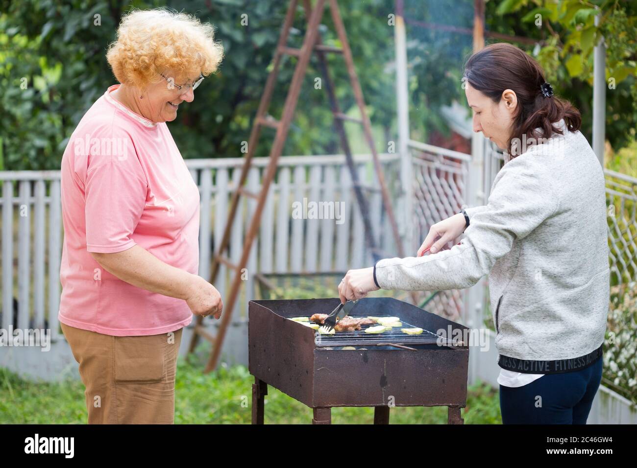 Women preparing the barbecue outside Stock Photo