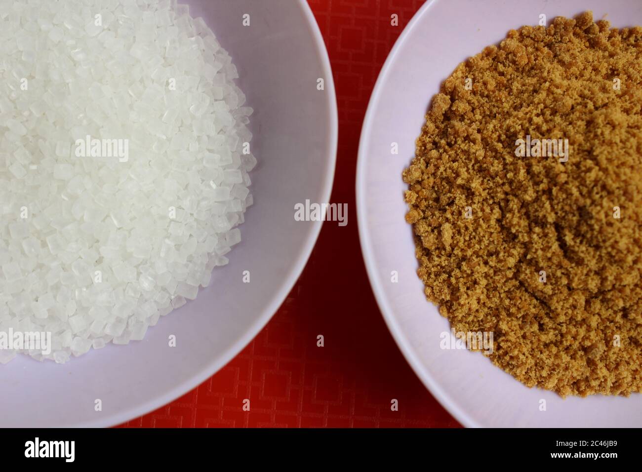 Closeup of unhealthy sugar and healthy jaggery powder Stock Photo