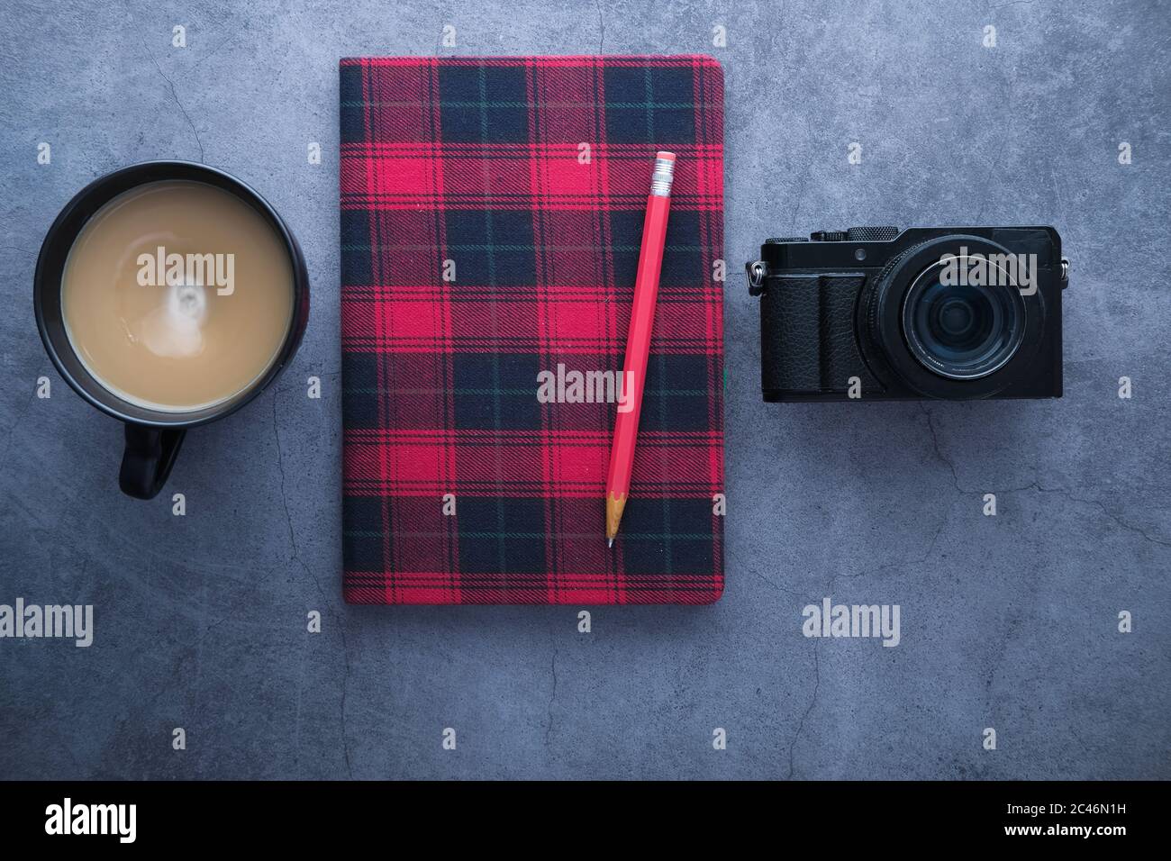 Classic camera with a red notepad and coffee on black background. Stock Photo