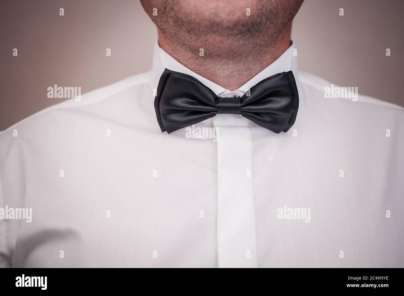 Dark black bowtie on the grooms neck Stock Photo