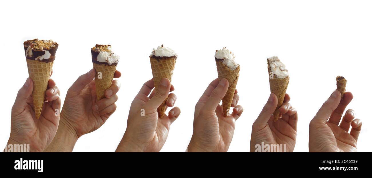 Sequence of an ice cream being eaten step by step. Man's hand holding a chocolate covered vanilla ice cream cone with peanut on white background Stock Photo