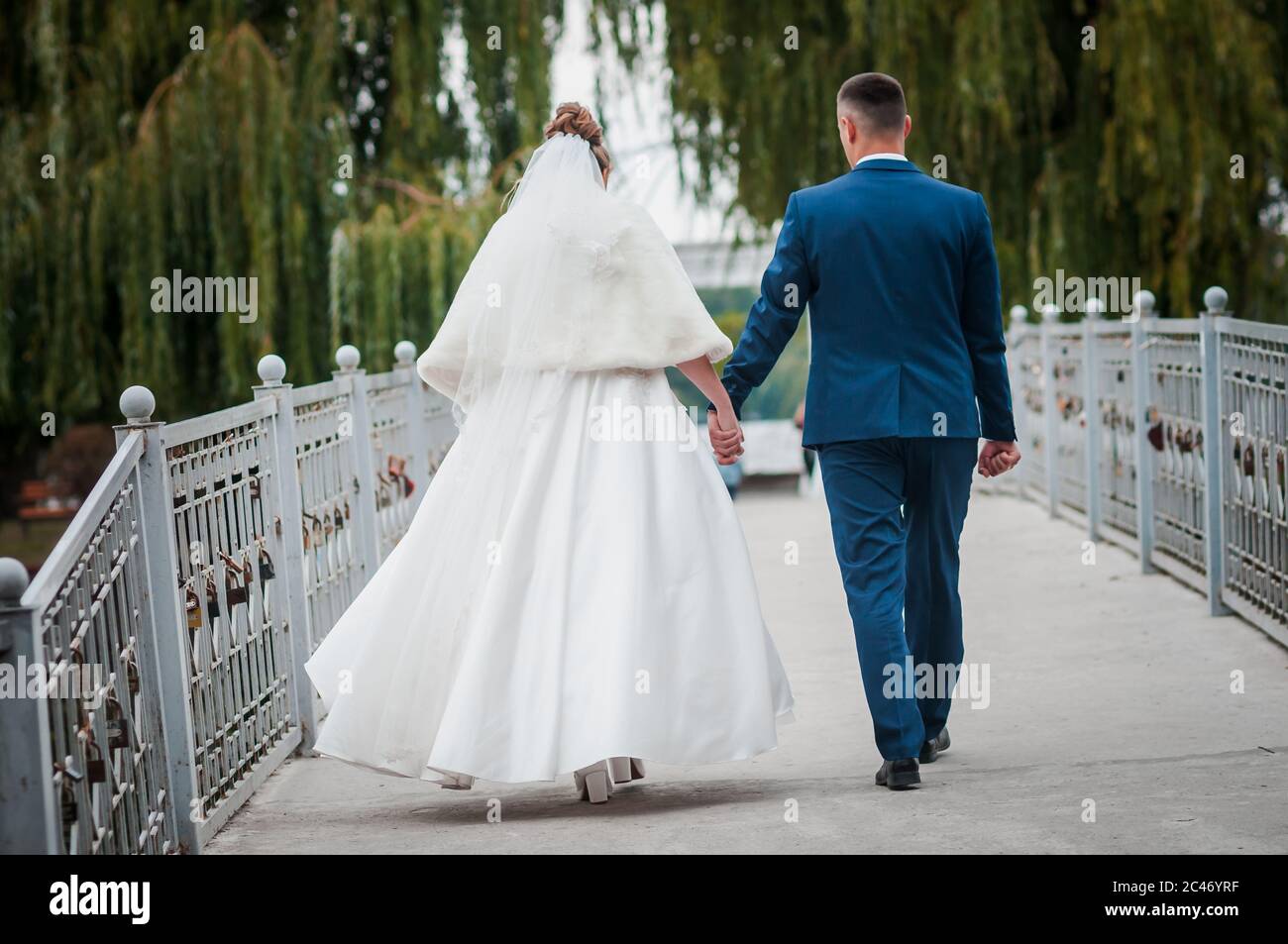 Bride and groom from behind walking on the road Stock Photo - Alamy