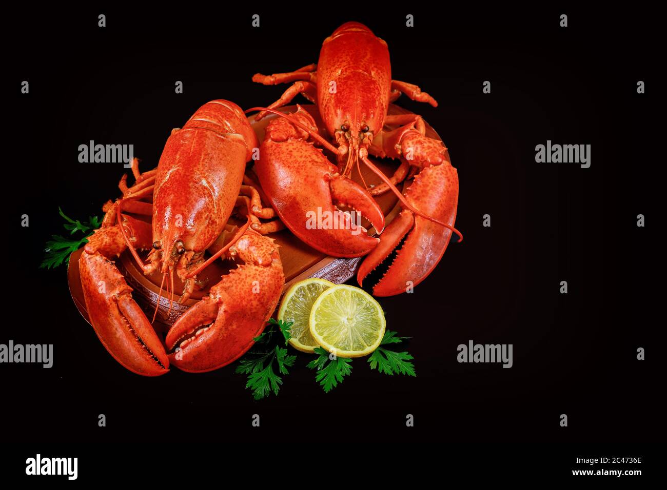Expensive seafood dish on black background with sliced lemon. Stock Photo