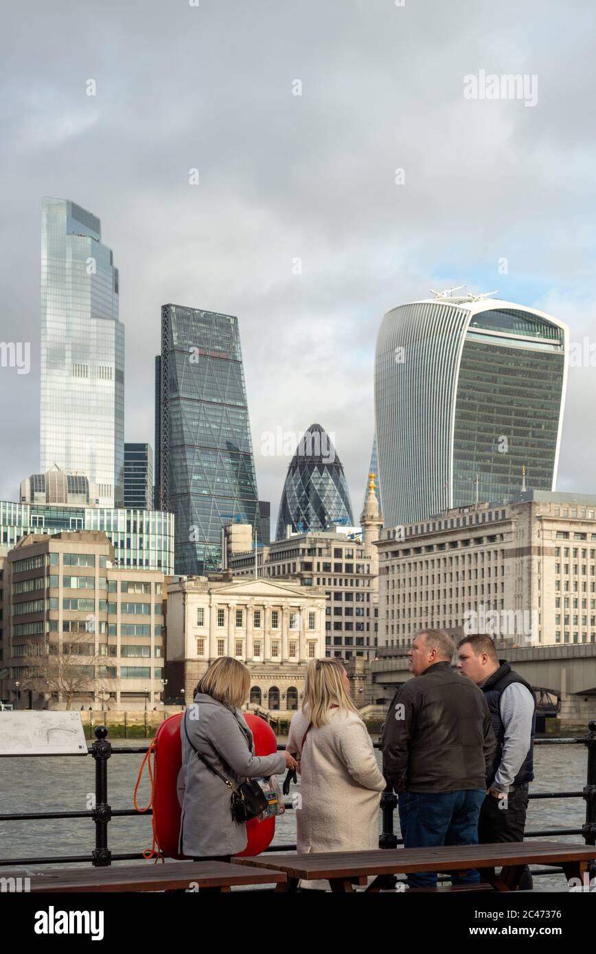 Group of tourists at Pickfords Wharf enjoying the view over River Thames and the City of London on bright cloudy day as seen in January 2020 Stock Photo