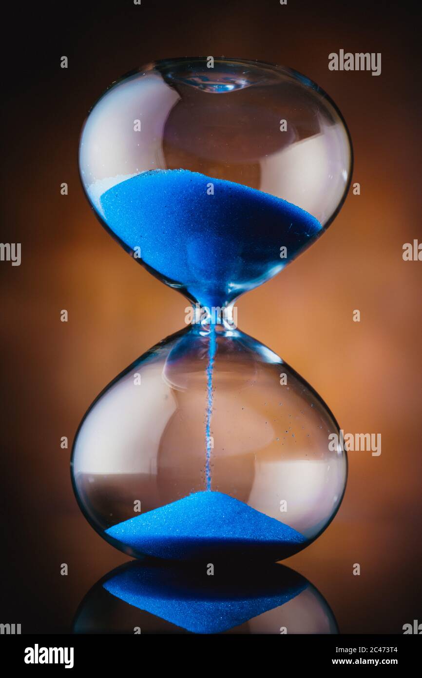 Flowing blue sand hourglass Stock Photo