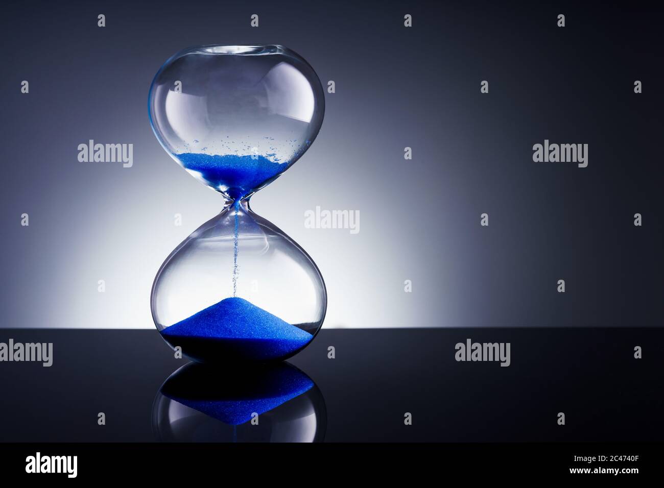 Flowing blue sand hourglass Stock Photo