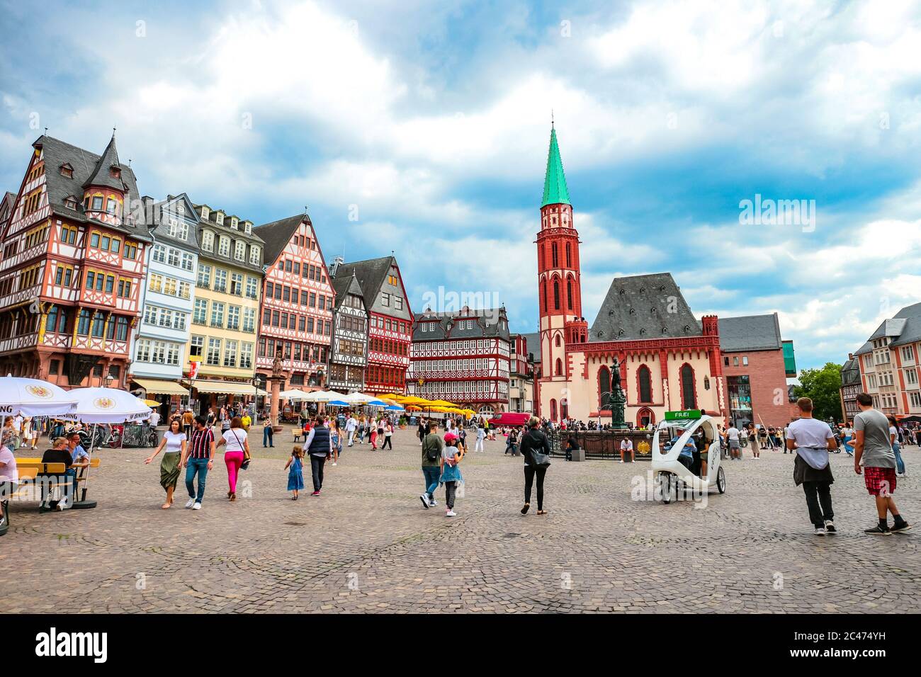 Tourists on historic Römerberg Square with Old St Nicholas Church in ...