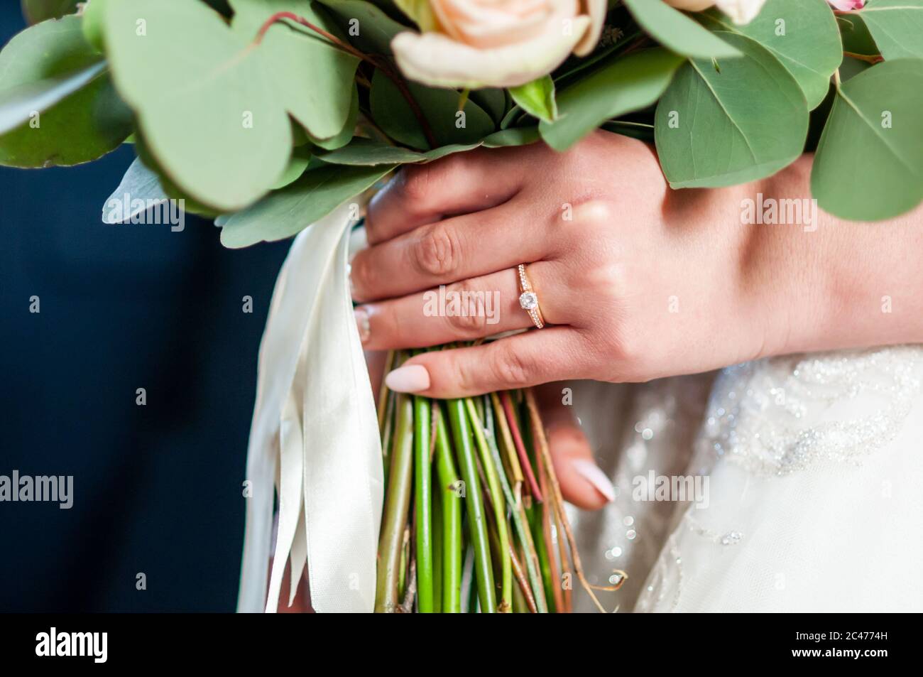 Bouquet of flowers in hand wedding ring of the bride Stock Photo