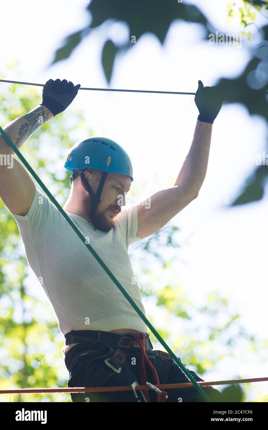 Rope adventure - man about to walk on the suspension rope bridge and ...