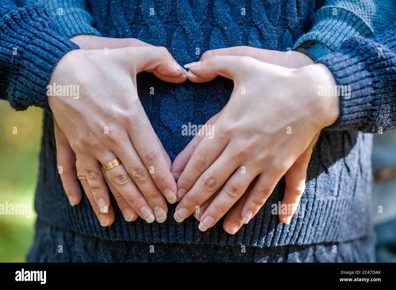 Pregnant woman and man hold hands in the shape of a heart Stock Photo ...