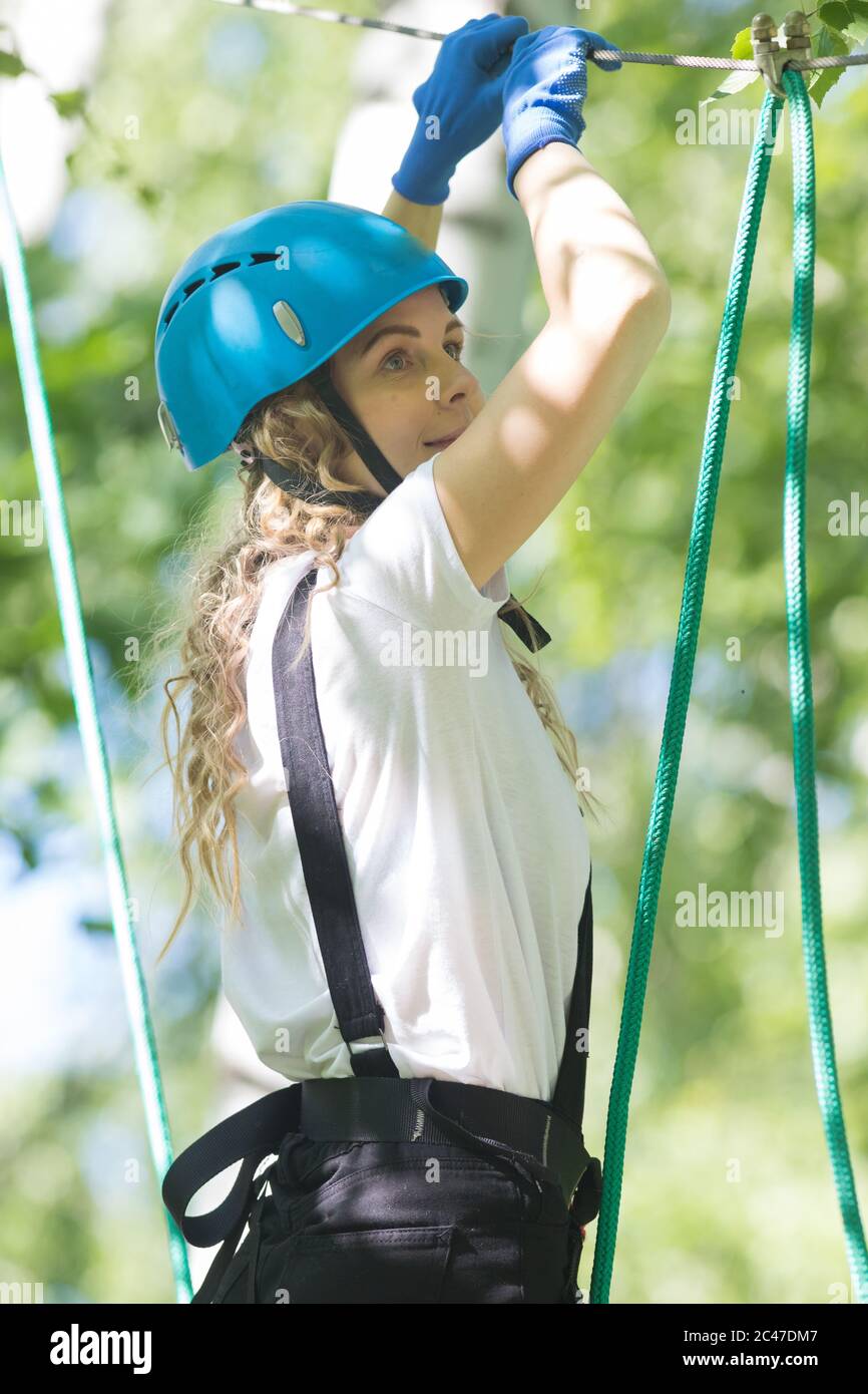 Girl Standing With Rope Rope adventure - smiling blonde woman standing on the rope. Mid shot ...