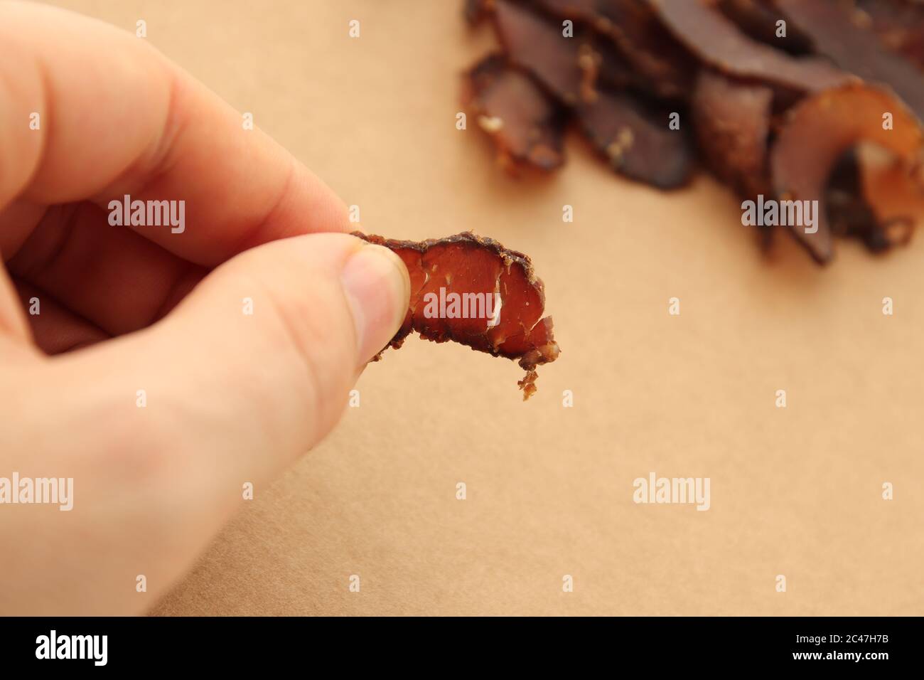 Biltong (dried meat) on a wooden board, this is a traditional food snack in South Africa. Stock Photo