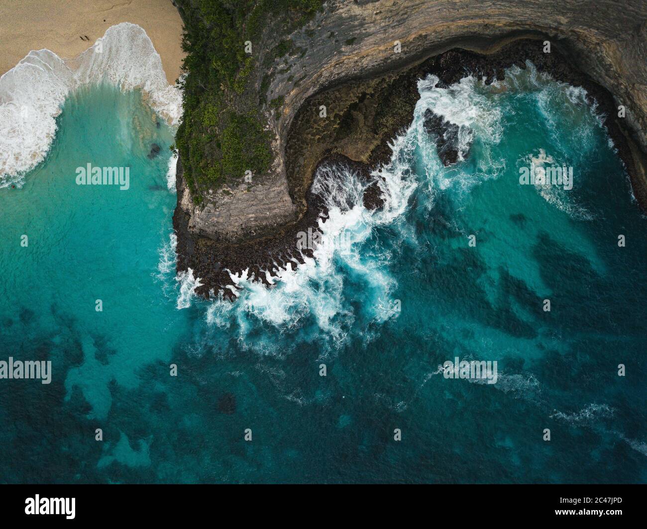 Aerial shot of the cliffs covered in greenery surrounded by the sea ...