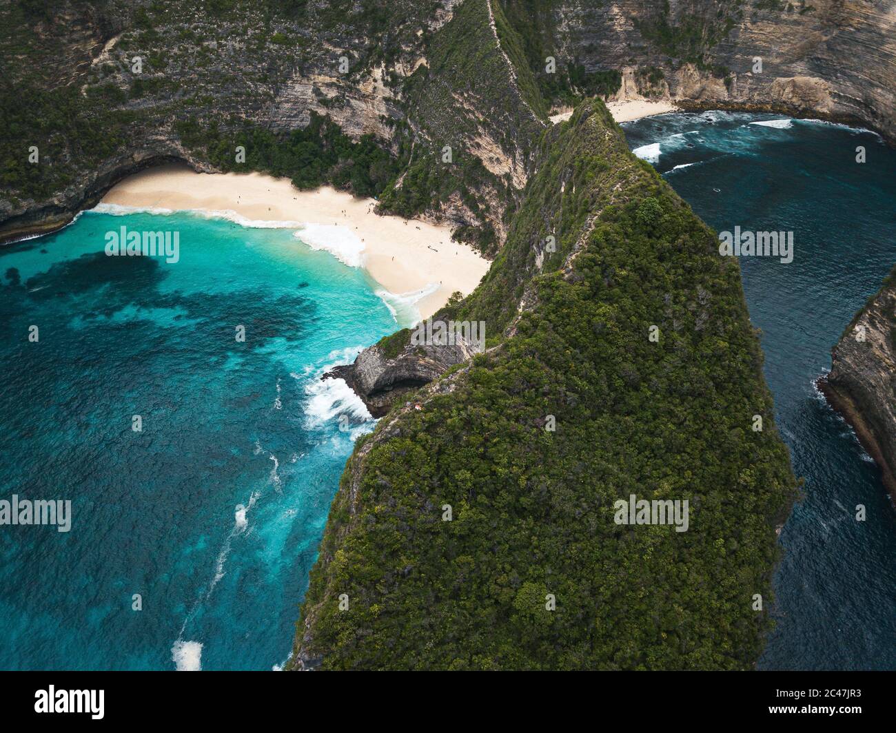 Bird's eye view of the cliffs covered in greenery surrounded by the sea ...