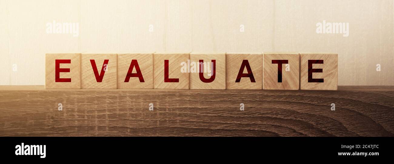 Evaluate word on natural wooden cubes on wooden table. Business and education concept Stock Photo